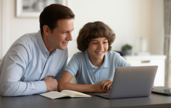 Parent and high school student reviewing college planning checklist on a laptop, symbolizing future education preparation.