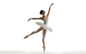 A graceful young ballet dancer in elegant attire performing on a clean white background, representing youth ballet programs