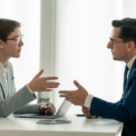 High-quality professional photograph showing a SaaS startup founder consulting with a specialized SaaS agreement attorney in a clean, white background setting